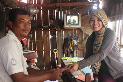 A volunteer collects money from a beneficiary of the micro-finance project Projects Abroad Micro-finance volunteer visits the home of a beneficiary in Phnom Penh, Cambodia
