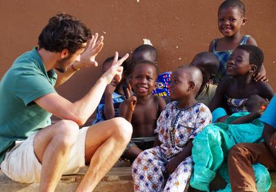 An International Development volunteer speaks to local children in Togo An International Development volunteer in Togo interacts with local children