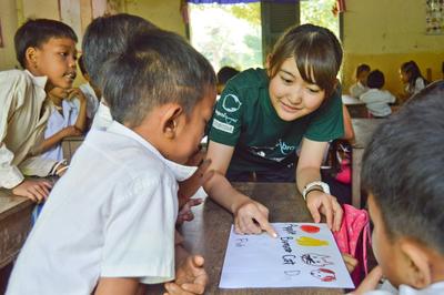 Japanese volunteer, Yuga, teaching her students how to say the names of fruit and animals in English High School Special Care volunteer working with the students during her class
