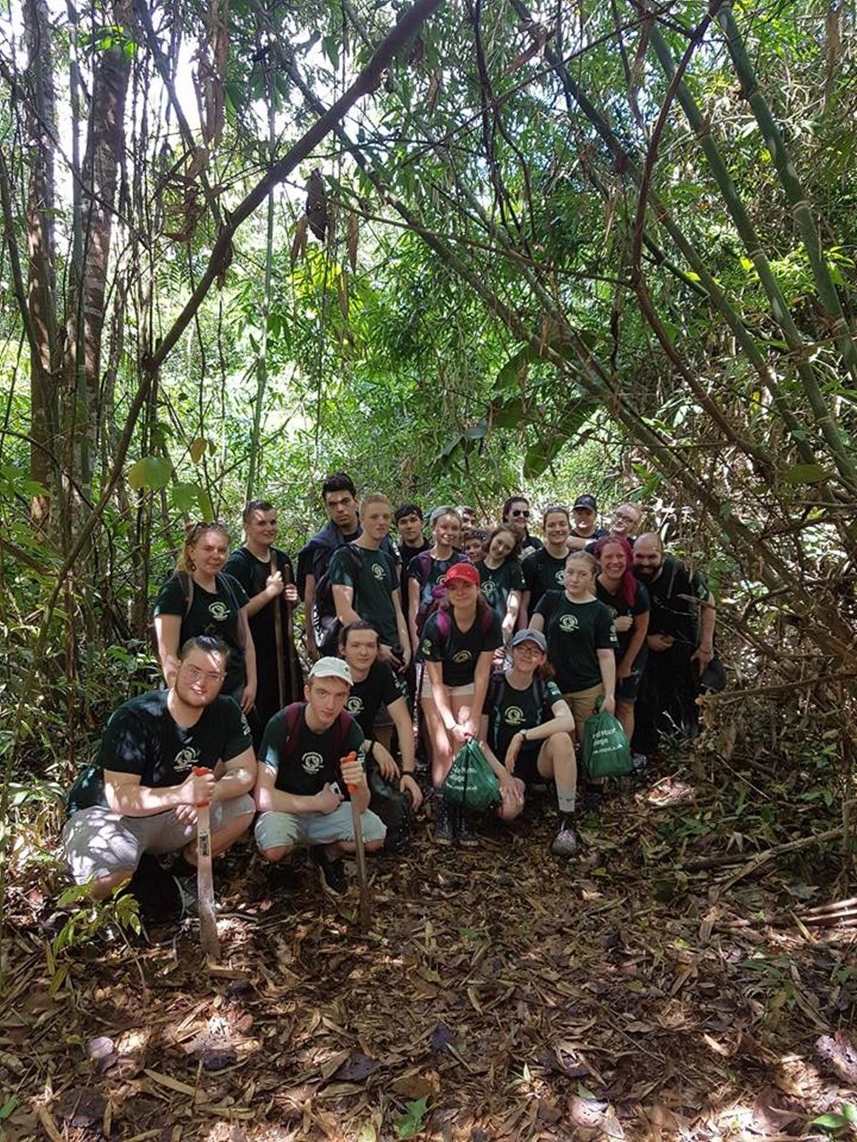 The group in the rainforest Cutting their way through thick vegetation, one of the groups pause for a photo