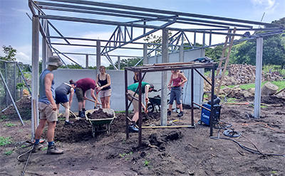 The SmithCorp Group working on a construction site during their Building Project Group trip volunteers working on the structure of a building